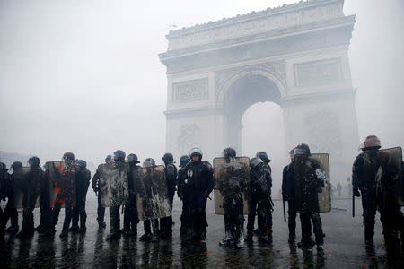 FILE PHOTO: French riot police stand guard at the Arc de Triomphe during clashes with protesters wearing yellow vests, a symbol of a French drivers' protest against higher diesel taxes, at the Place de l'Etoile in Paris, France, December 1, 2018. REUTERS/Stephane Mahe/File Photo