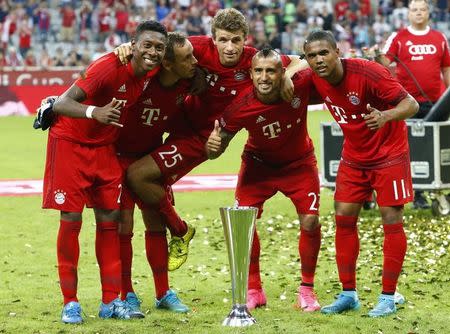 Bayern Munich's David Alaba, Rafinha, Thomas Mueller, Arturo Vidal and Douglas Costa (L-R) pose with the trophy after winning their pre-season Audi Cup tournament final soccer match against Real Madrid in Munich, Germany, August 5, 2015. REUTERS/Michaela Rehle