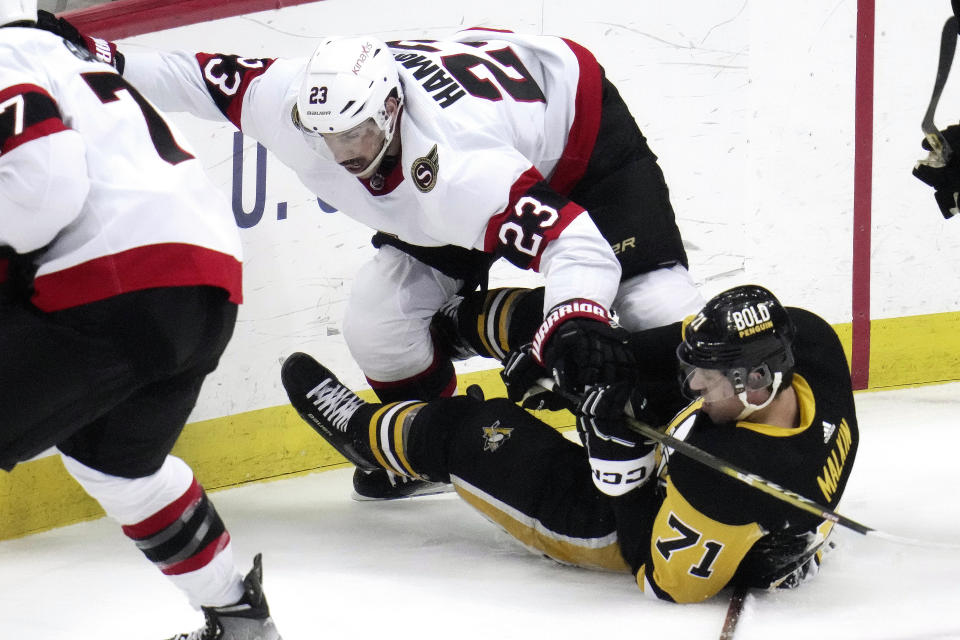 Ottawa Senators' Travis Hamonic (23) and Pittsburgh Penguins' Evgeni Malkin (71) collide during the first period of an NHL hockey game in Pittsburgh, Monday, March 20, 2023. (AP Photo/Gene J. Puskar)