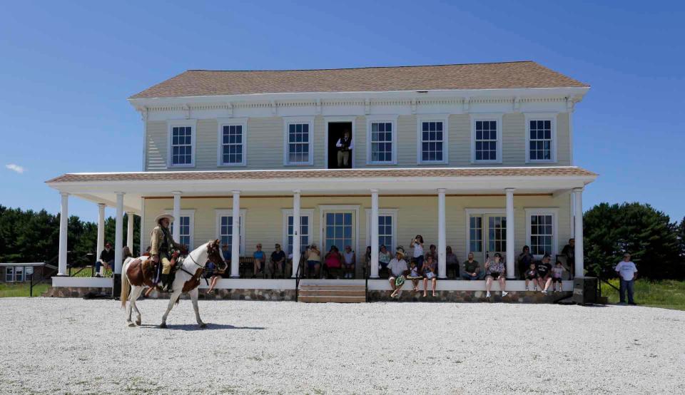 People sit in chairs on the porch of the Meeme House while waiting for the Buffalo Bill Wild West Show to start at Pinecrest Historical Village, Saturday, August 14, 2021, in Manitowoc, Wis.