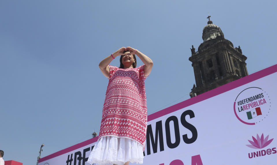 Opposition presidential candidate Xochitl Galvez flashes a heart hand sign at a campaign rally, in the Zocalo, Mexico City's main square, Sunday, May 19, 2024. She represents a coalition that includes the PRI, which governed Mexico for 71 years, and she began her campaign as a political phenomenon backed by the country's business elites. But her popularity has been declining. (AP Photo/Ginnette Riquelme)
