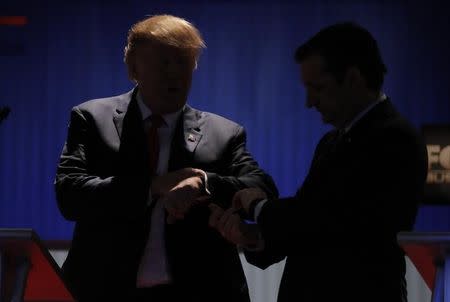 Republican U.S. presidential candidates businessman Donald Trump (L) and rival Senator Ted Cruz check their watches together during a break as the program goes long at the Fox Business Network Republican presidential candidates debate in North Charleston, South Carolina January 14, 2016. REUTERS/Chris Keane