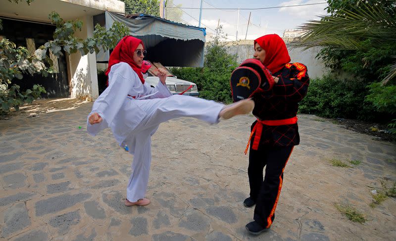 La entrenadora de artes marciales Seham Amer practica movimientos de defensa personal con una estudiante en una casa en Saná