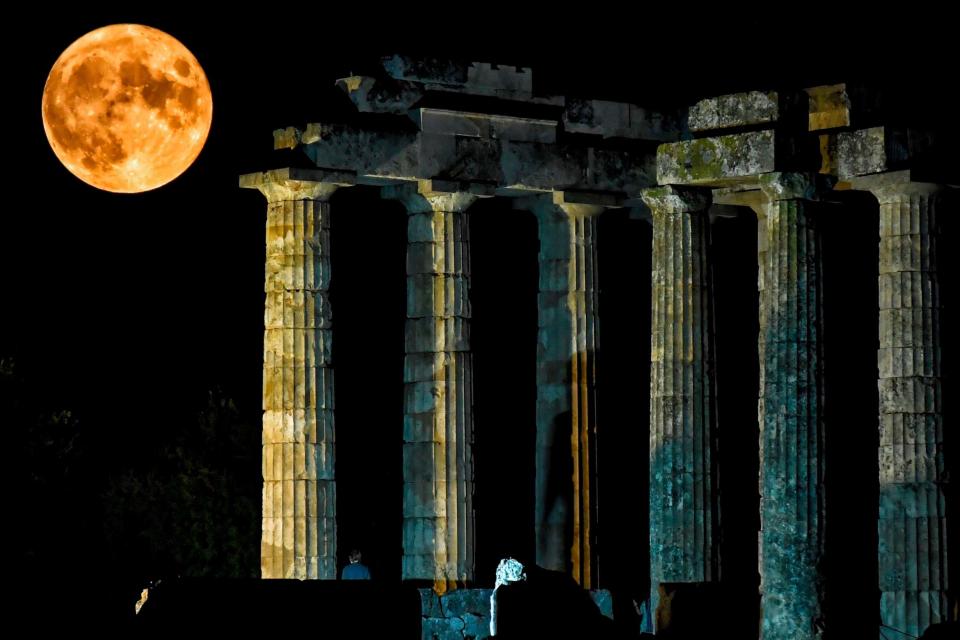 The full moon rises behind the ancient temple of Zeus in Nemea, Greece (AFP via Getty Images)