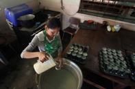 Volunteer helps to prepare breakfast for students at the San Agustin school in La Canada de Urdaneta