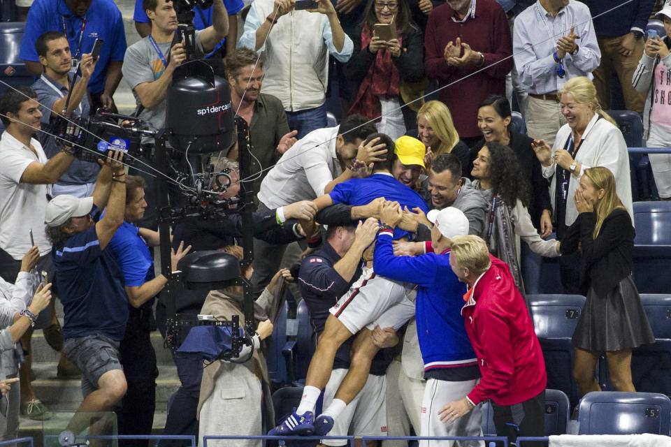 Novak Djokovic of Serbia jumps into his player's box to be congratulated by family and friends  (REUTERS/Carlo Allegri)