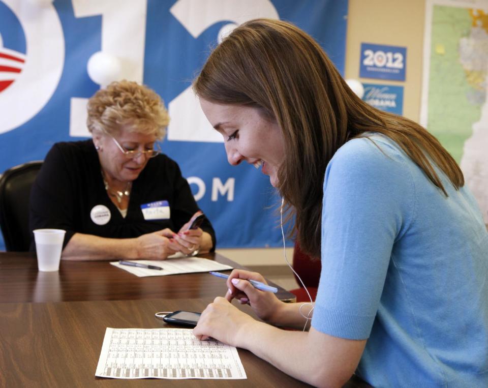 This photo taken on March 14, 2012 shows volunteer Anita McIntyre, left, and staff member Angela Grills making calls on a phone bank at an Obama campaign office in Lakewood, Colo. A handful of nurses and other volunteers took up their cell phones last week to call voters and talk up the health care overhaul. The volunteers were targeting elderly women. Holding up a sheet of talking points about the health law, campaign field director Tami Parker told about a dozen volunteers that the health care law faces a Supreme Court challenge later this month. "We need to talk about how the American Care Act helps women, especially elderly women," Parker said. The talking points ended with an argument in bold: "Some politicians want to take away these new benefits, and put insurance companies back in charge." (AP Photo/Ed Andrieski)