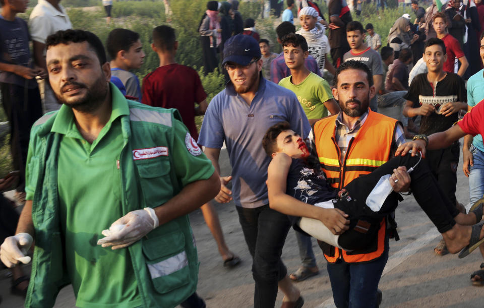 Medics evacuate a wounded youth during a protest at the entrance of Erez border crossing between Gaza and Israel, in the northern Gaza Strip, Tuesday, Sept. 4, 2018. The Health Ministry in Gaza says several Palestinians were wounded by Israeli fire as they protested near the territory's main personnel crossing with Israel. (AP Photo/Adel Hana)