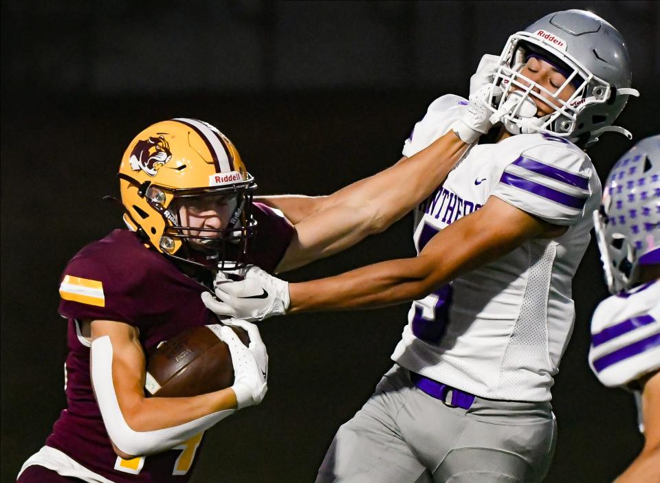 Bloomington North’s Cole Grupenhoff (14) stiff-arms Bloomington South’s Elijah Walker (5) during the IHSAA sectional semi-final football game at Bloomington North on Friday, Oct. 27, 2023.