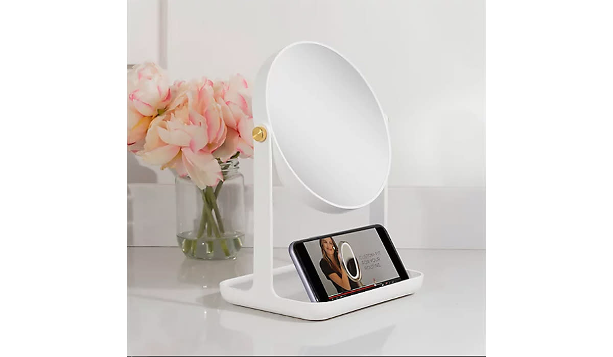 White mirror on vanity with phone in stand showing makeup tutorial