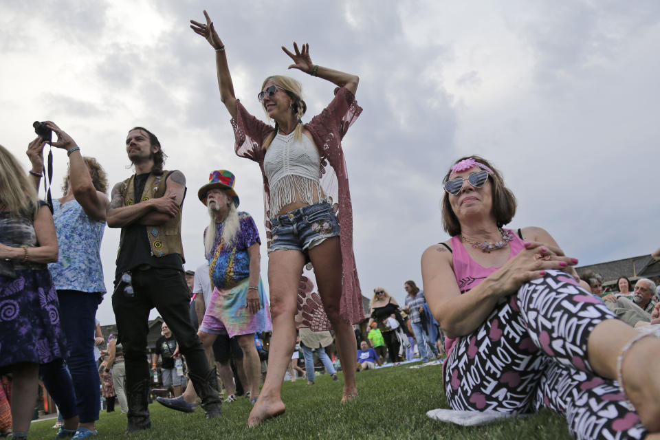 People listen and dance as Arlo Guthrie plays at a Woodstock 50th anniversary event in Bethel, New York.
