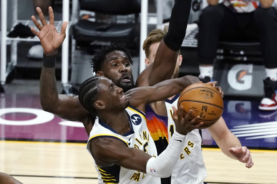 Indiana Pacers guard Caris LeVert (22) drives past Phoenix Suns center Deandre Ayton (22) during the first half of an NBA basketball game Saturday, March. 13, 2021, in Phoenix. (AP Photo/Rick Scuteri)