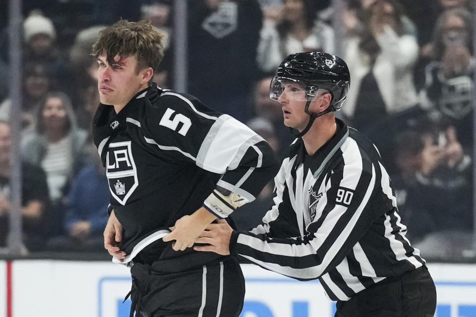 Los Angeles Kings defenseman Andreas Englund (5) leaves the ice after fighting with Boston Bruins center Trent Frederic (11) during the second period of an NHL hockey game Saturday, Oct. 21, 2023, in Los Angeles. (AP Photo/Ashley Landis)