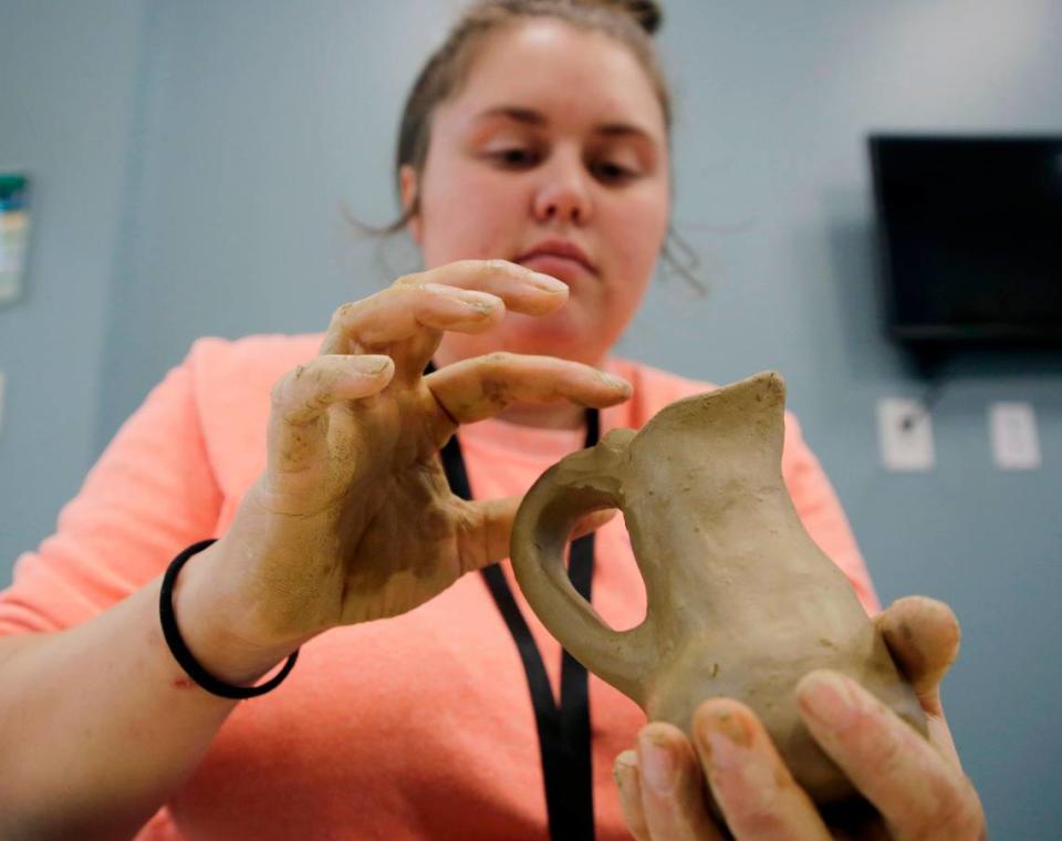 Cheyenne Sanders molds a pitcher with clay Friday at the Catawba Reservation’s Senior Center.