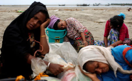 Exhausted Rohingya refugees rest on the shore after crossing the Bangladesh-Myanmar border by boat through the Bay of Bengal in Shah Porir Dwip, Bangladesh, September 10, 2017. REUTERS/Danish Siddiqui