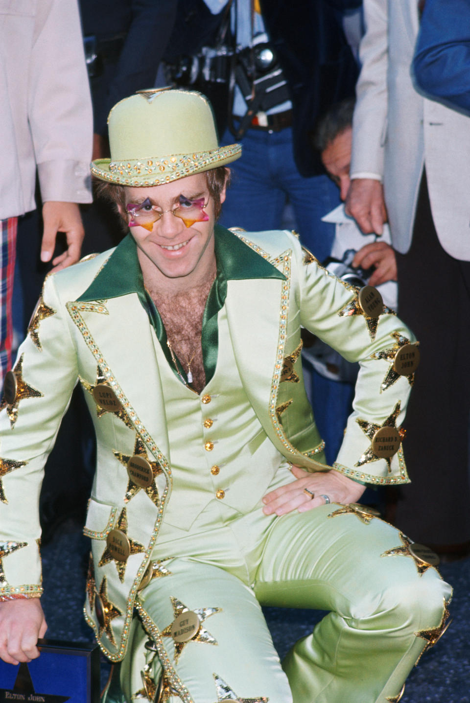 John is honored with a star on the Hollywood Walk of Fame in Los Angeles in October 1975. He wears a suit emblazoned with named stars, including his own.