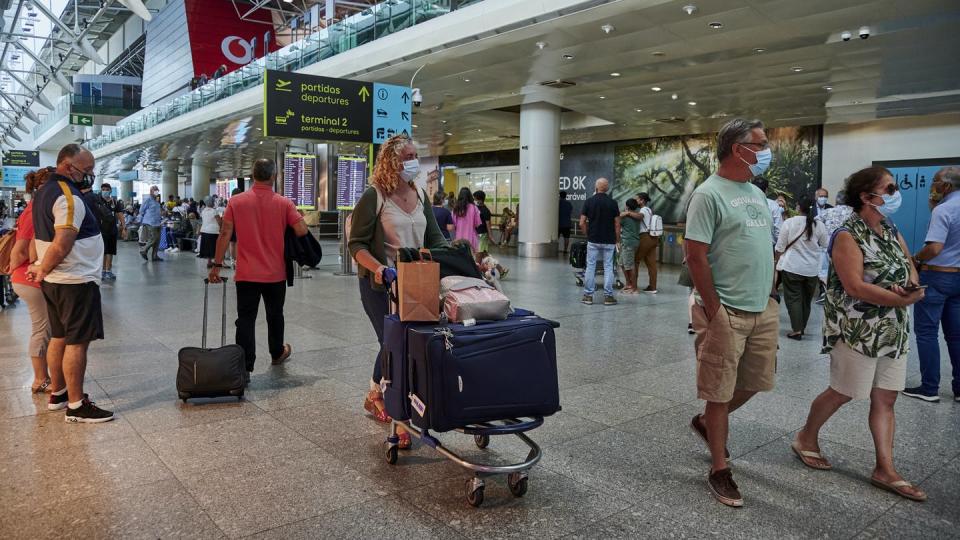 Mask-clad passengers pass through an airport arrival hall in Lisbon, Portugal in September 2021 amid the COVID-19 pandemic.