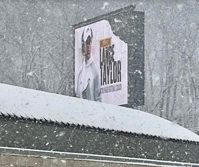 <em>Lance Taylor on the signage at Waldo Stadium where the Broncos play football on a snowy Friday afternoon in Kalamazoo, Mich. (Photo/Levi Rickert)</em>