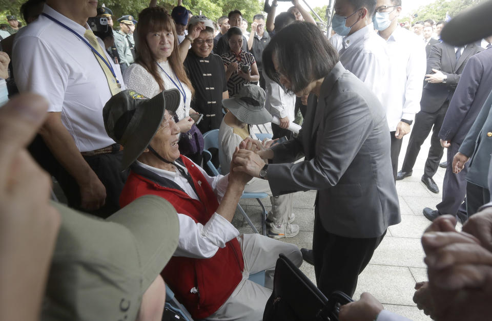 Taiwan's President Tsai Ing-wen, right, honors the families of the fallen during a ceremony commemorating the 65th anniversary of deadly attack by China on Kinmen island, in Kinmen, Taiwan, Wednesday, Aug. 23, 2023. (AP Photo/Chiang Ying-ying)