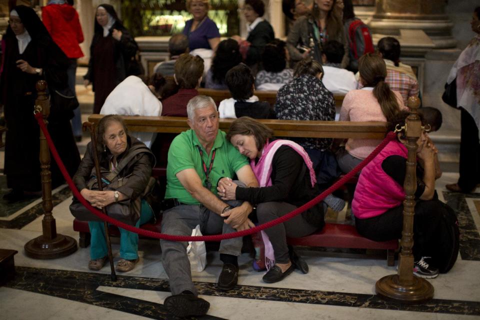 Worshipers rest inside St. Peter's Basilica at the Vatican, Saturday, April 26, 2014. Pilgrims and faithful are gathering in Rome to attend Sunday's ceremony at the Vatican where Pope Francis will elevate in a solemn ceremony John XXIII and John Paul II to sainthood. (AP Photo/Emilio Morenatti)