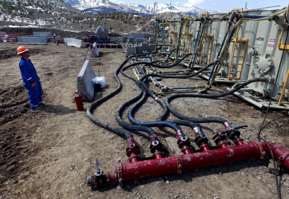 FILE - In this March 29, 2013, file photo, a worker helps monitor water pumping pressure and temperature, at an oil and natural gas extraction site, outside Rifle, on the Western Slope of Colorado. A federal judge has ruled that the Trump administration's leading steward of public lands has been serving unlawfully and blocked him from continuing in the position. U.S. District Judge Brian Morris said Friday, Sept. 25, 2020, that U.S. Bureau of Land Management acting director William Perry Pendley was never confirmed to the post by the U.S. Senate and served unlawfully for 424 days. (AP Photo/Brennan Linsley, File)