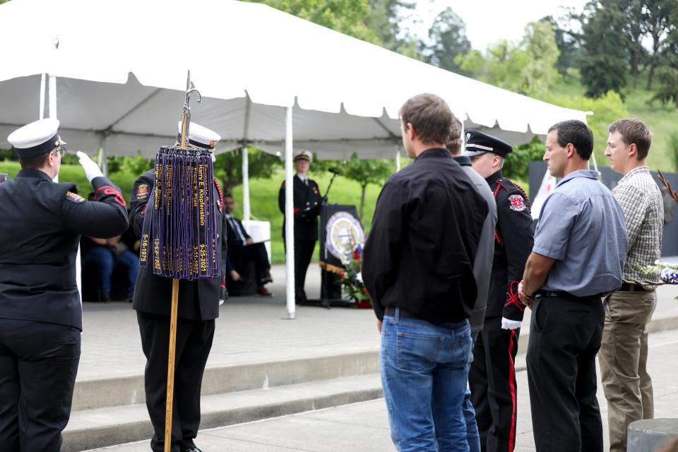 A ribbon representing Captain Harry E. Klopfenstein is placed on the staff representing fallen Oregon firefighters during the Fallen Firefighters Memorial Ceremony on Thursday, June 9, 2022 in Salem, Ore.