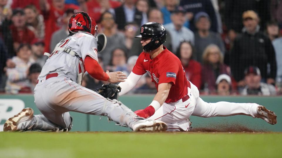 Boston Red Sox's Enrique Hernandez, right, tries to elude a tag by Cincinnati Reds catcher Tyler Stephenson, left, during the fifth inning of a baseball game at Fenway Park, Tuesday, May 30, 2023, in Boston. Hernandez was out on the play. (AP Photo/Charles Krupa)