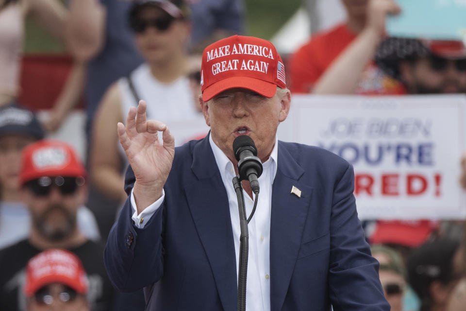 Donald Trump speaking at a rally post-conviction wearing a "Make America Great Again" cap.