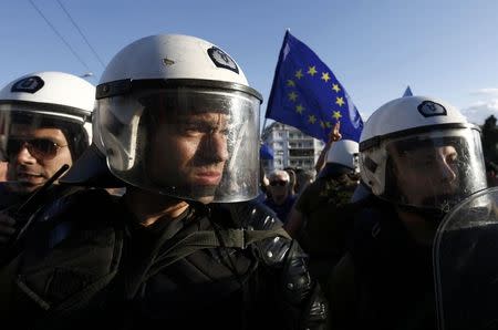 Riot policemen stand between anti-austerity and pro-euro protesters in front of the parliament building during a rally calling on the government to clinch a deal with its international creditors and secure Greece's future in the Eurozone, in Athens, Greece, June 22, 2015. REUTERS/Yannis Behrakis