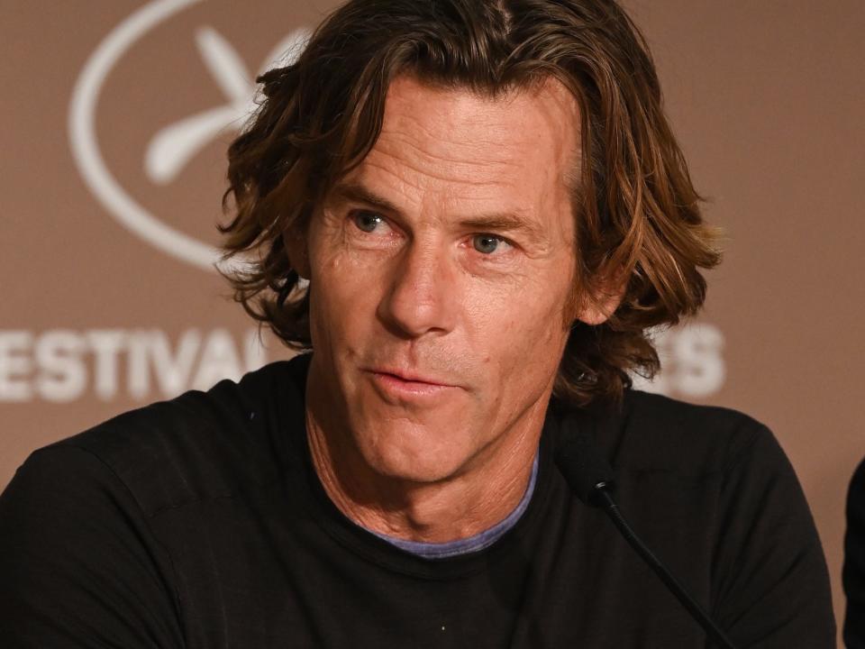 Danny Moder, wearing a dark shirt, sits onstage during a panel at the 2021 Cannes Film Festival.