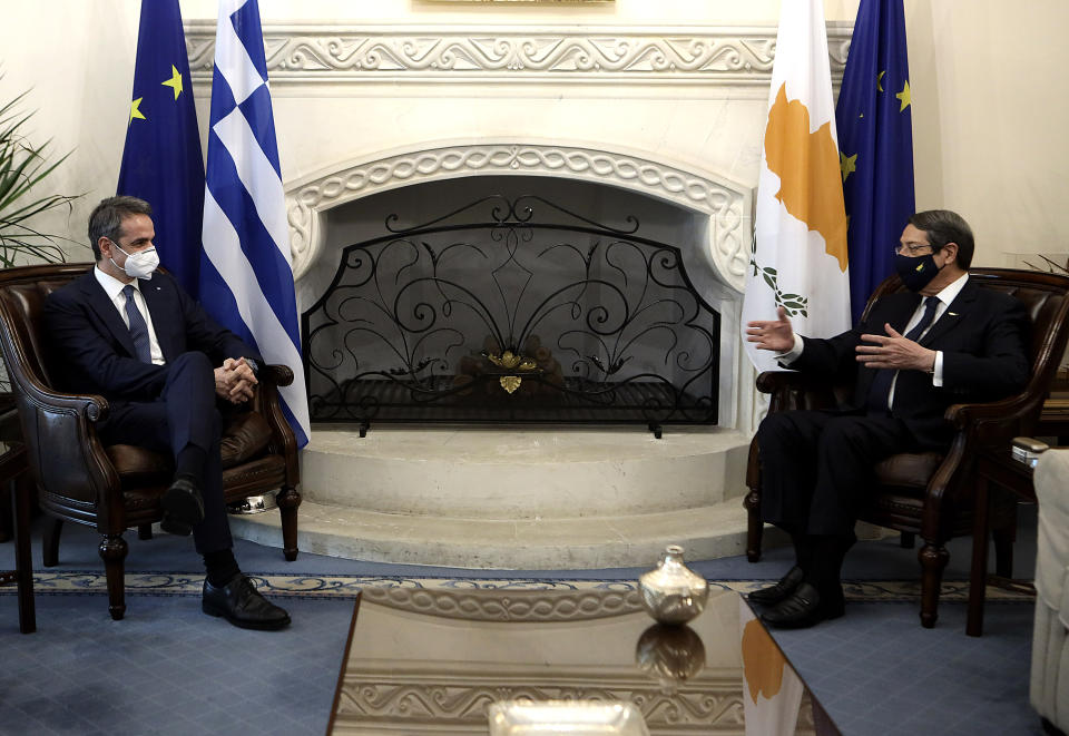 This image provided by Cyprus' press and information office shows Cyprus President Nicos Anastasiades, right, talking with Greece's Prime minister Kyriakos Mitsotakis during their meeting at the presidential palace in capital Nicosia, Cyprus, Monday, Feb. 8, 2021. Mitsotakis is in Cyprus on a one day official visit. (Stavros Ioannides, PIO via AP)