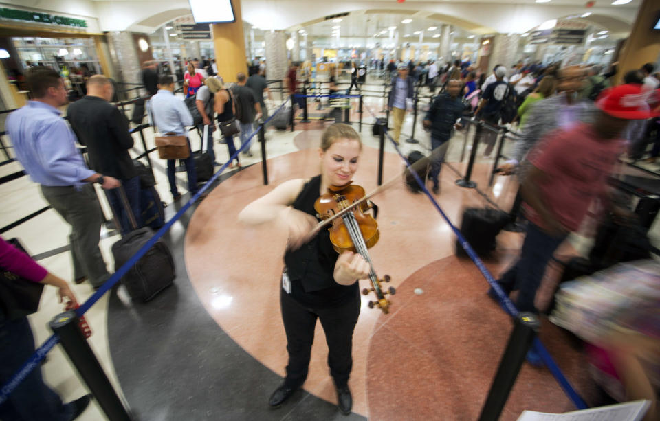 Eine Geigerin vertreibt den Wartenden auf dem Hartsfield-Jackson Atlanta International Airport mit süßen Klängen die Zeit. (AP Photo/David Goldman)