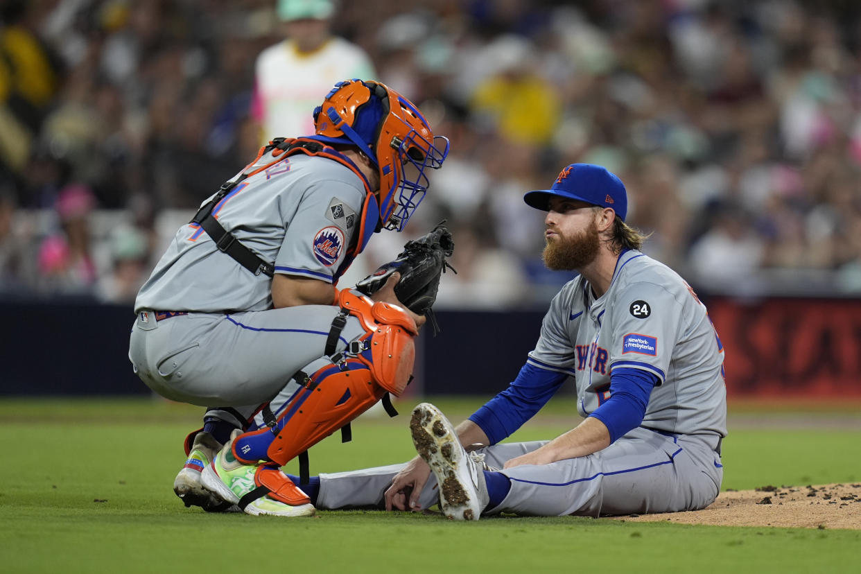 New York Mets starting pitcher Paul Blackburn, right, talks to catcher Francisco Alvarez after getting hit by a line out by San Diego Padres' David Peralta during the third inning of a baseball game Friday, Aug. 23, 2024, in San Diego. (AP Photo/Gregory Bull)