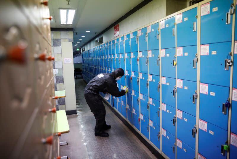 A South Korean soldier cleans lockers with disinfectant at a cram school for civil service exams, following the rise in confirmed cases of coronavirus disease (COVID-19) in Daegu