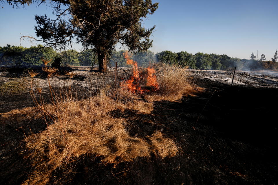 A small fire burns in a field after Palestinians in Gaza sent incendiary balloons over the border between Gaza and Israel, Near Nir Am, southern Israel, June 15,2021. / Credit: AMIR COHEN/REUTERS