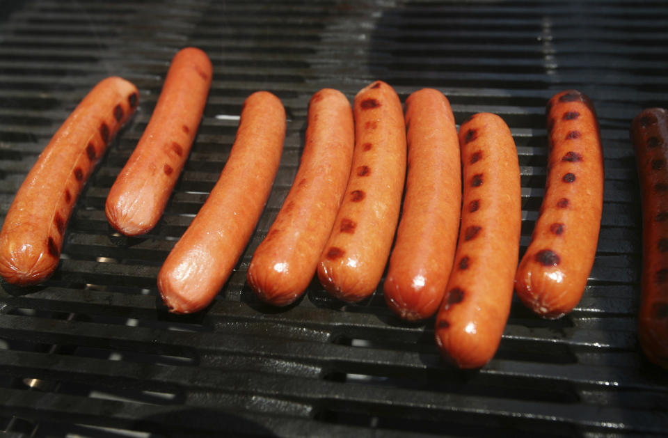 FILE - This June 10, 2008 file photo shows hot dogs on a grill in New York's Times Square. (AP Photo/Mark Lennihan, File)