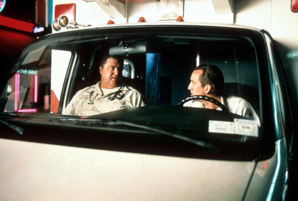 John Goodman and Nicolas Cage sitting in an ambulance