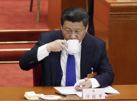 Chinese President Xi Jinping drinks from a cup during the opening of the annual full session of the National People's Congress, the country's parliament, at Great Hall of the People, in Beijing, March 5, 2015. REUTERS/Jason Lee (CHINA - Tags: POLITICS)