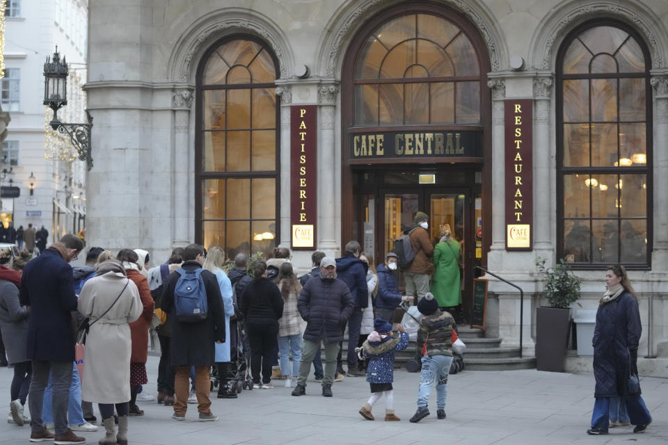 People wait in line to enter a cafe in Vienna, Austria, Sunday, Nov. 21, 2021. The Austrian government announced a nationwide lockdown that will start Monday and comes as average daily deaths have tripled in recent weeks and hospitals in heavily hit states have warned that intensive care units are reaching capacity.(AP Photo/Vadim Ghirda)