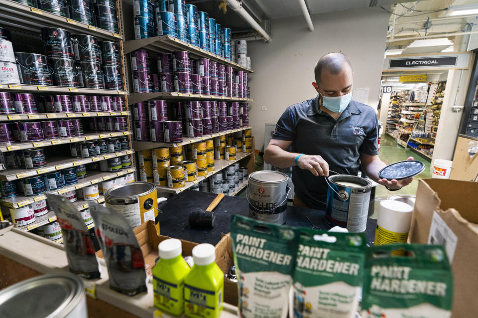 Billy Wommack, purchasing director at the W.S. Jenks & Sons hardware, opens a gallon of paint at the mixing station of the hardware store's paint department, Friday, Sept. 24, 2021, in northeast Washington. The chemical shortages, and a near doubling of oil prices in the past year, mean higher prices for many goods. (AP Photo/Manuel Balce Ceneta)