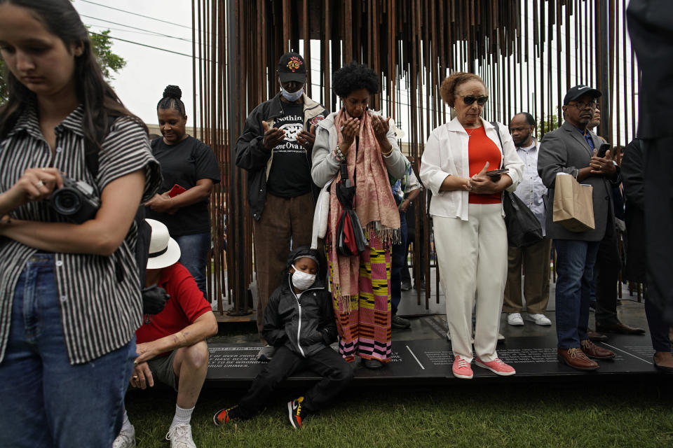 People pray at the dedication of a prayer wall outside of the historic Vernon African Methodist Episcopal Church in the Greenwood neighborhood during the centennial of the Tulsa Race Massacre, Monday, May 31, 2021, in Tulsa, Okla. The church was largely destroyed when a white mob descended on the prosperous Black neighborhood in 1921, burning, killing, looting and leveling a 35-square-block area. (AP Photo/John Locher)