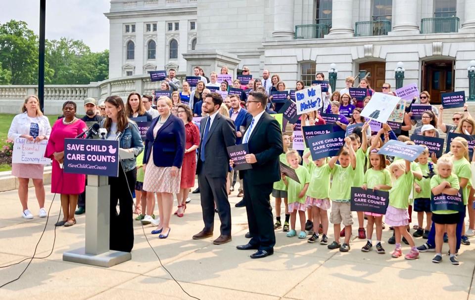 Brooke Skidmore, of New Glarus, Wis., speaks on the impact of impact of funding reductions on child care at the Wisconsin State Capitol, Thursday, June 15, 2023, in Madison, Wis. At right are children from her day care,  Growing Tree child care center in New Glarus, Wis. 