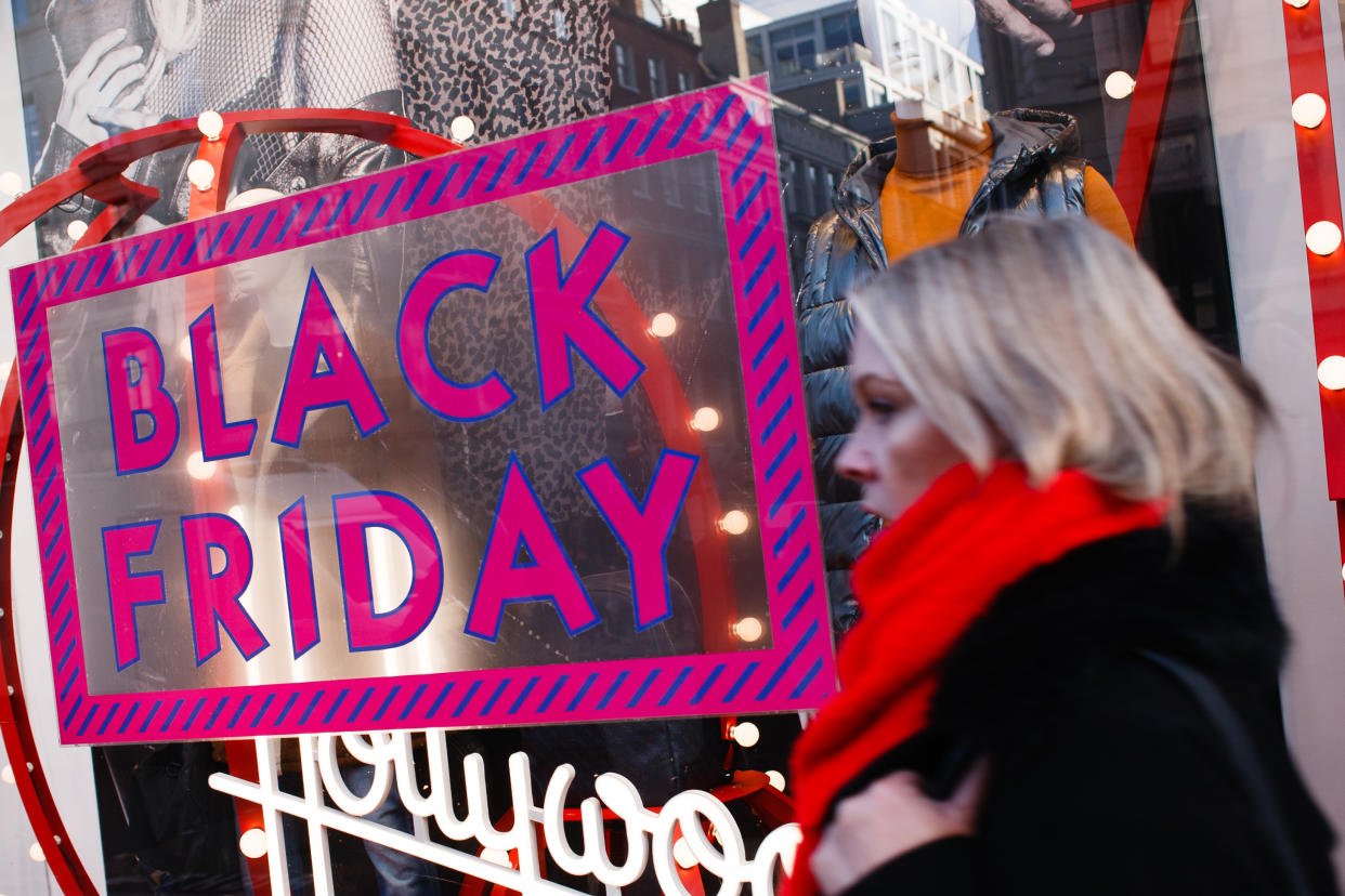 A woman walks past a sign advertising Black Friday discounts at a clothing store on Regent Street in London, England, on November 29, 2019. (Photo by David Cliff/NurPhoto via Getty Images)