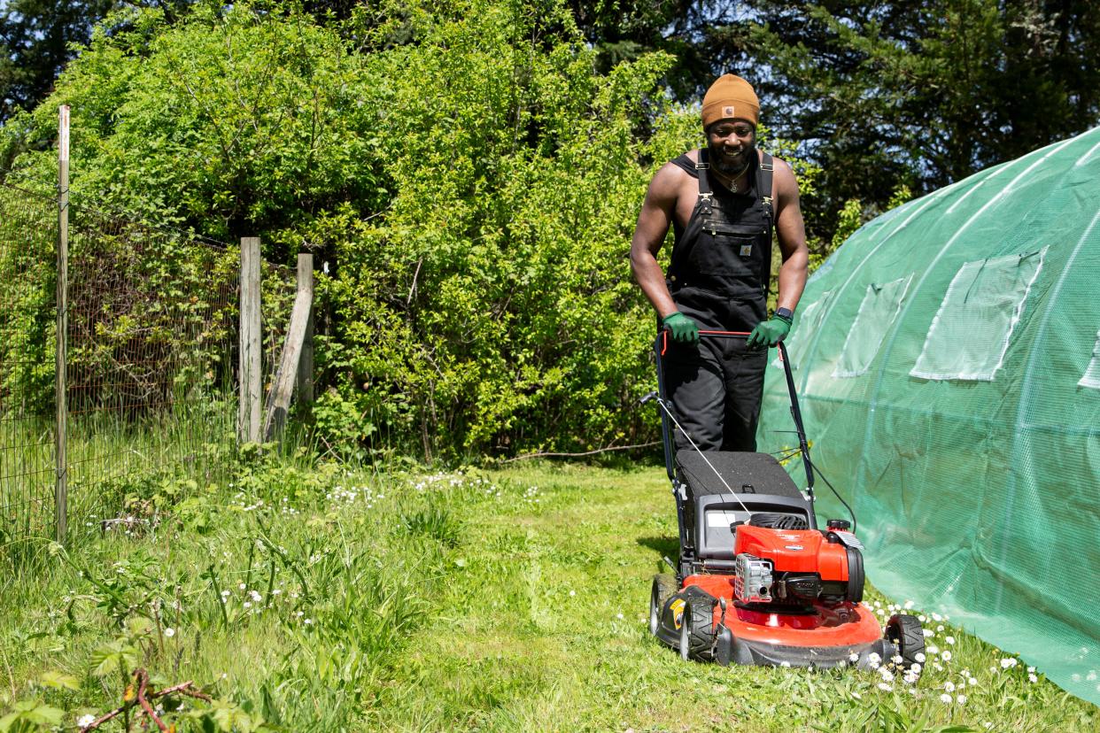 Javon Deese mows the lawn at Black Joy Farm on Sunday, April 21, 2024, in Keizer, Ore.