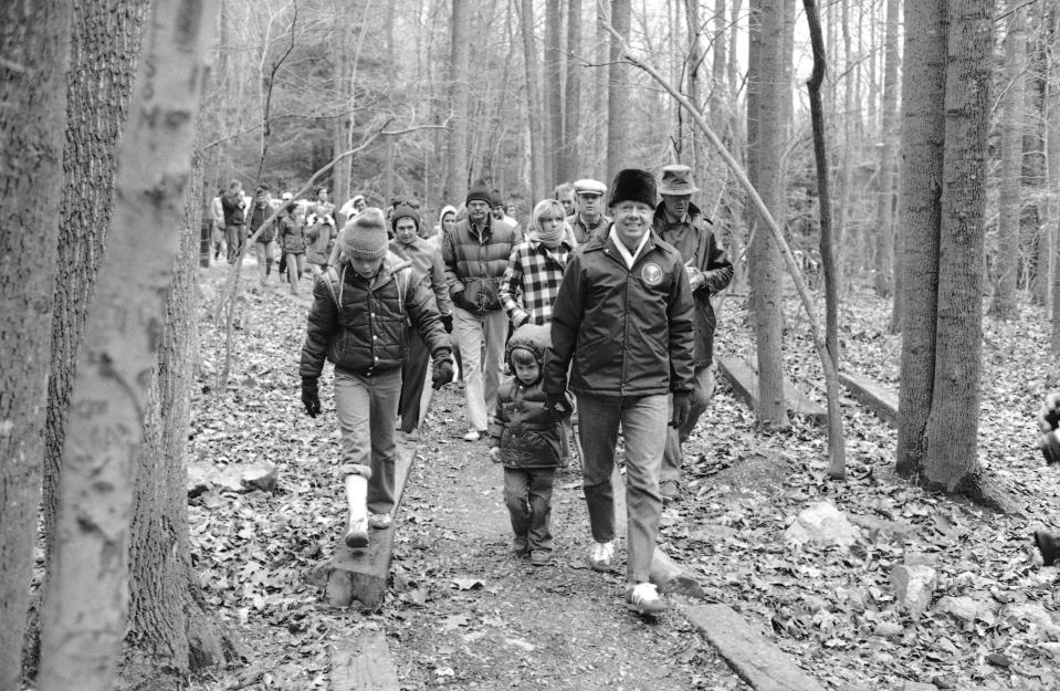 President Jimmy Carter, holding the hand of his grandson Jason, leads members of the Carter family and others on a holiday outing to Cunningham Falls State Park near Camp David, Maryland, Nov. 25, 1978.