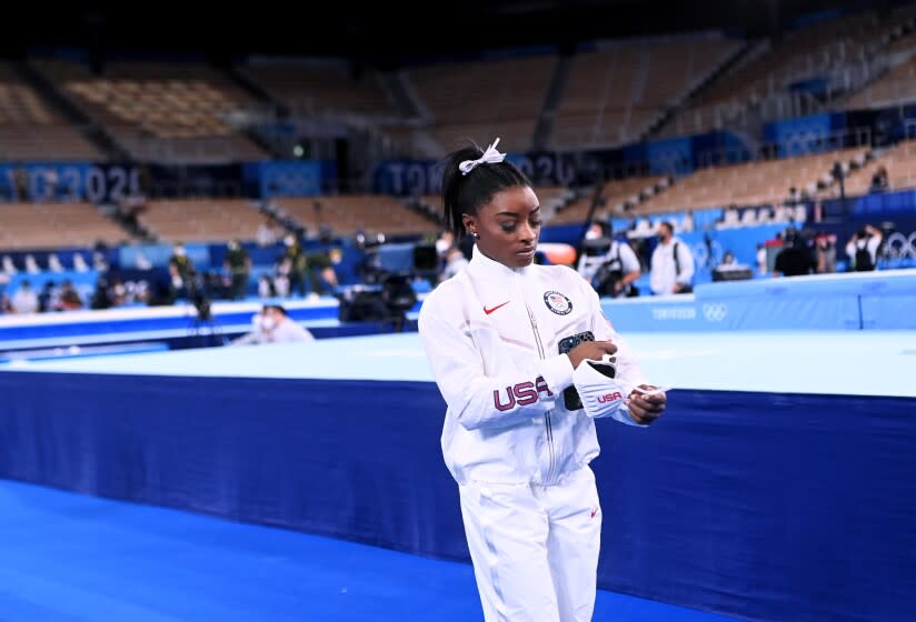 Simone Biles walks alone after the women's team final at the Tokyo Olympics.