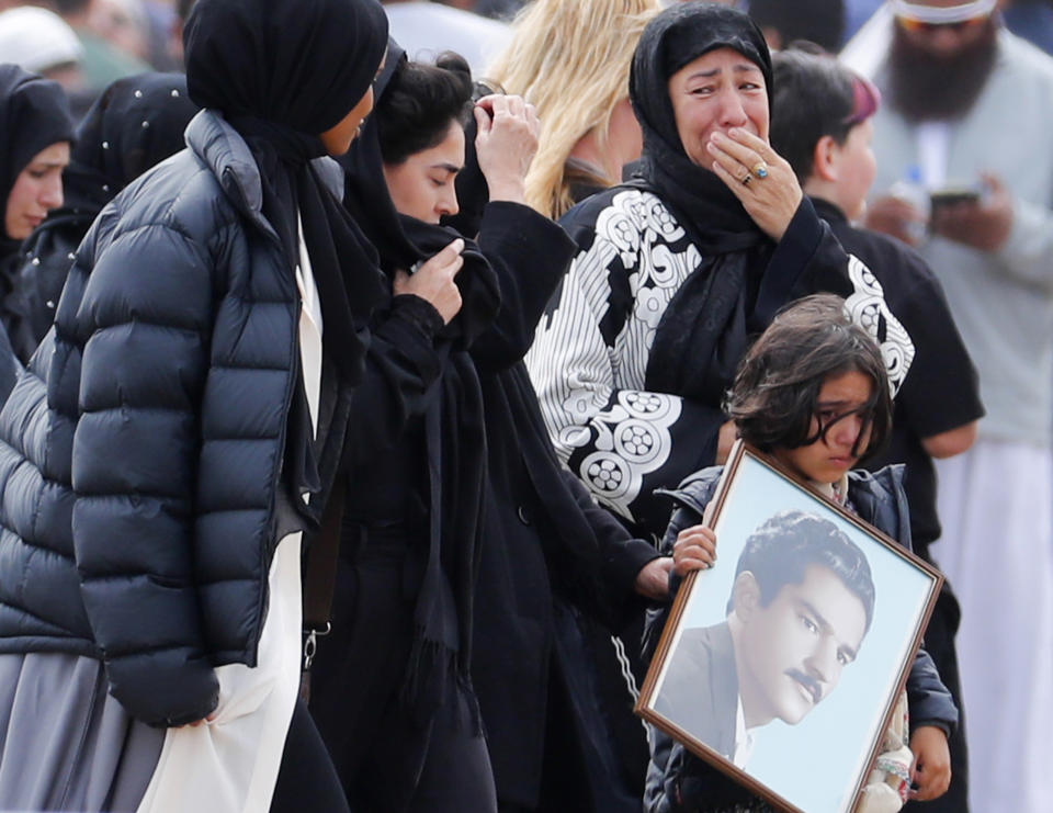 FILE - In this Thursday, March 21, 2019 file photo, mourners arrive for a burial service of a victim from the March 15 mosque shootings, at the Memorial Park Cemetery in Christchurch, New Zealand. New Zealand Prime Minister Jacinda Ardern was hailed around the world for her decisive response to the two mosque shootings by a white nationalist who killed 50 worshippers. For many Muslims, her most consequential move was immediately labeling the attack an act of terrorism. Community leaders and researchers say that for too long, terrorism was considered a "Muslim problem" and that a double standard persists when attacker is white and non-Muslim. (AP Photo/Vincent Thian, File)