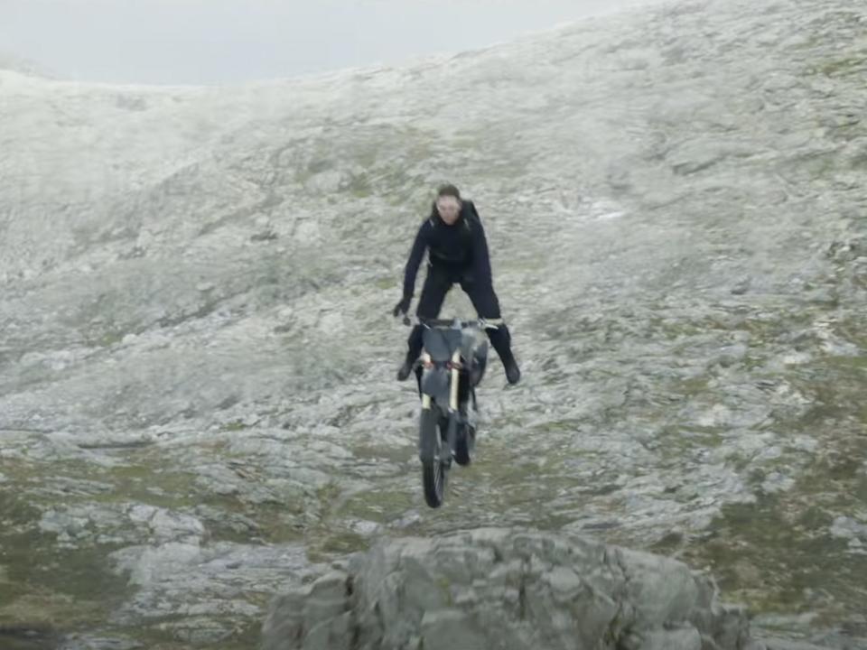 Tom Cruise jumping off a motorbike in mid-air in "Mission: Impossible - Dead Reckoning Part One."