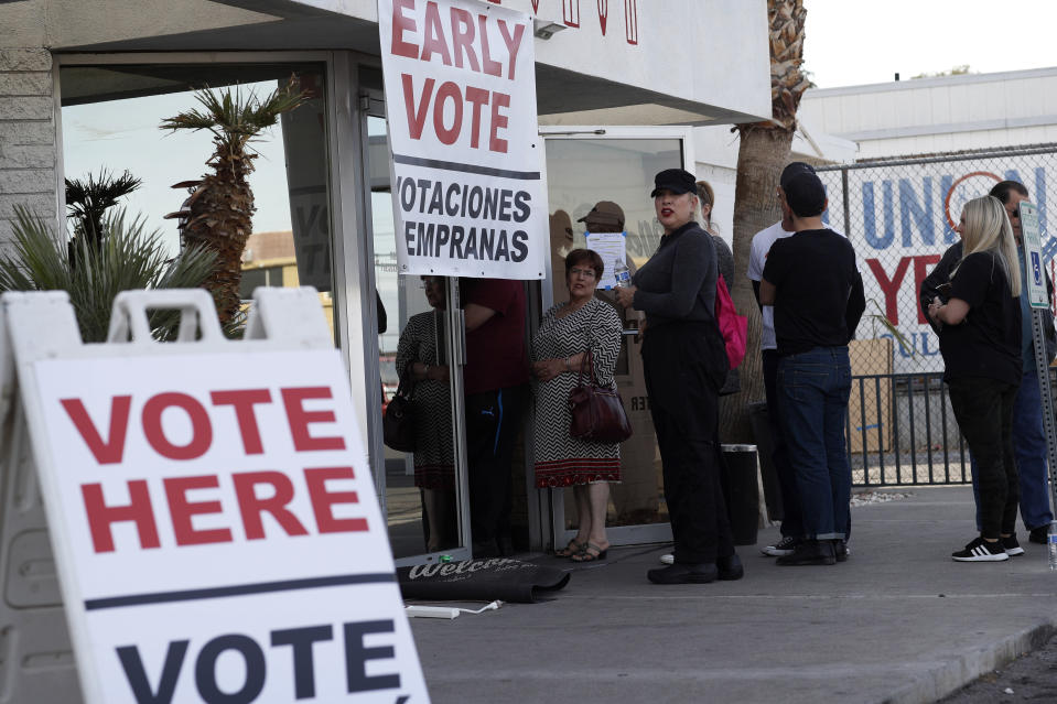 FILE - In this Feb. 15, 2020, file photo, people wait in line at an early voting location at the culinary workers union hall in Las Vegas. The Democratic presidential contest has moved to immigrant-heavy Nevada, but the issues of immigration are seldom getting a thorough airing on the campaign trail. Candidates usually throw in a quick condemnation of President Donald Trump's hard-line policies but have shied away from outlining their own immigration positions. Immigration groups say that points to a potential vulnerability for whoever is the Democratic nominee later this year. (AP Photo/John Locher, File)