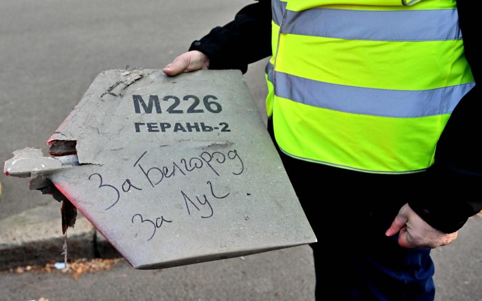 A police expert holds a fragment of a drone with a handwritten inscription reading "For Belgorod. For Luch" - SERGEI SUPINSKY/AFP